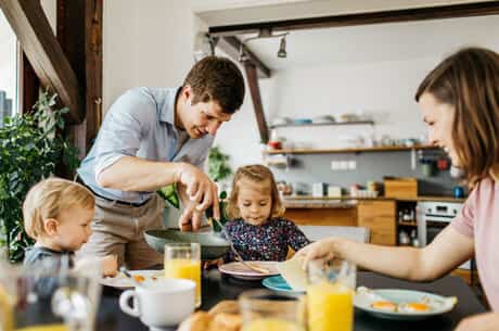 father serving family breakfast