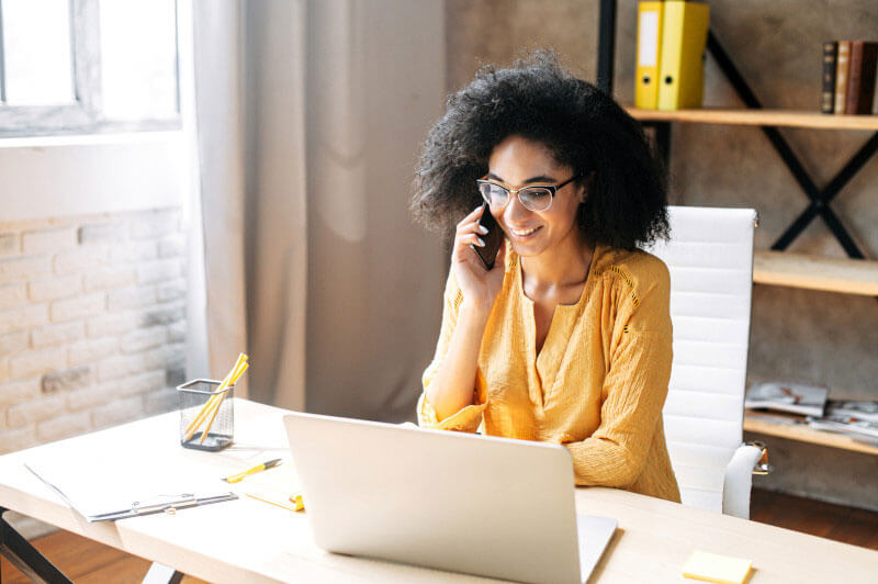 Woman on phone by computer